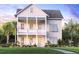 Charming two-story home with a quaint porch, manicured lawn, and lush landscaping at 2056 Ten Point Dr, Charleston, SC 29492