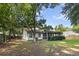 Spacious backyard with lush lawn, mature trees, a screened porch, and privacy fence at 210 Basswood Ave, Summerville, SC 29483