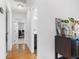 Hallway features hardwood floors, a decorative table, and easy access to various rooms in the home at 210 Basswood Ave, Summerville, SC 29483