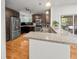 View of the kitchen showing stainless appliances, granite counters, wood floors, dark cabinets, and a breakfast bar at 210 Basswood Ave, Summerville, SC 29483