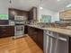Kitchen featuring stainless appliances, granite counters, dark cabinets, mosaic tile backsplash, and wood floors at 210 Basswood Ave, Summerville, SC 29483