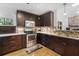 Kitchen with granite counters, stainless steel appliances, dark wood cabinets, wood floors and tiled backsplash at 210 Basswood Ave, Summerville, SC 29483