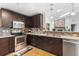 Kitchen with stainless appliances, granite counters, dark wood cabinets, tiled backsplash, and wood floors at 210 Basswood Ave, Summerville, SC 29483