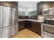 Kitchen with stainless steel appliances, dark wood cabinets, granite counters and backsplash, and wood floors at 210 Basswood Ave, Summerville, SC 29483