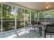 Relaxing screened-in porch with comfortable seating and views of the backyard and green trees at 210 Basswood Ave, Summerville, SC 29483