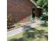 Backyard area featuring green metal chairs, small garden, and a brick walkway leading to the home's entrance at 214 Winter St, Moncks Corner, SC 29461