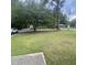 View of a house and lawn, shaded by large trees, in a quiet residential neighborhood at 214 Winter St, Moncks Corner, SC 29461