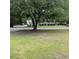View of a well-maintained home and yard with a large shade tree at 214 Winter St, Moncks Corner, SC 29461