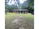 Wide shot of a brick home featuring a cozy front porch with inviting blue chairs and a manicured lawn at 214 Winter St, Moncks Corner, SC 29461