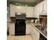 Bright kitchen with white cabinets, black appliances, and practical countertop space at 214 Winter St, Moncks Corner, SC 29461