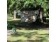 Exterior view of an old outbuilding with a small window, set amidst lush greenery and a large shade tree at 214 Winter St, Moncks Corner, SC 29461