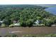 Waterfront homes with swimming pools sit amongst dense trees along the river at 2180 Wappoo Hall Rd, Charleston, SC 29412