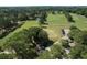 Aerial view of a lush golf course with tree-lined fairways, water features and manicured greens at 2180 Wappoo Hall Rd, Charleston, SC 29412
