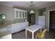Charming kitchen with white cabinets, a farmhouse sink, tile countertops, and a vintage-style dining table and chairs at 2180 Wappoo Hall Rd, Charleston, SC 29412