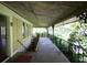 Spacious covered porch with decorative iron railings, perfect for relaxing and enjoying the surrounding nature at 2180 Wappoo Hall Rd, Charleston, SC 29412
