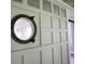 Close-up of a vintage porthole window set into a wainscotted wall overlooking another room at 2180 Wappoo Hall Rd, Charleston, SC 29412