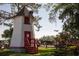 Charming windmill structure with red accents set amidst lush greenery and landscaping at 2180 Wappoo Hall Rd, Charleston, SC 29412