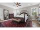 Primary bedroom showcasing a four poster bed, windows, ceiling fan and decorative rug at 2206 Magnolia Meadows Dr, Mount Pleasant, SC 29464