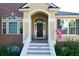 Stunning front entrance with stairs leading to a black front door, American flag, and brick facade at 2206 Magnolia Meadows Dr, Mount Pleasant, SC 29464