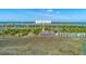 Aerial view of 221 E Mariners Cay homes nestled amongst trees with tennis courts and marshlands at 221 E Mariners Cay # 221, Folly Beach, SC 29439