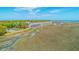 Aerial view showcasing waterfront townhomes with marshland backdrop near a tennis court at 221 E Mariners Cay # 221, Folly Beach, SC 29439