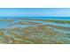 Expansive aerial shot of coastal landscape featuring marshlands, waterways, and a distant beachfront community at 221 E Mariners Cay # 221, Folly Beach, SC 29439