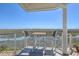 Inviting balcony with table and chairs, offering tranquil marsh views and a peaceful outdoor living space at 221 E Mariners Cay # 221, Folly Beach, SC 29439