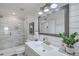 Well-lit bathroom with white shiplap walls, a large mirror, double sinks, and a glass-enclosed shower at 221 E Mariners Cay # 221, Folly Beach, SC 29439