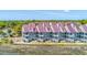 Waterfront townhome exterior with screened balconies providing marshland views, near community tennis court at 221 E Mariners Cay # 221, Folly Beach, SC 29439