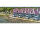 Waterfront townhome exterior featuring screened balconies with views of marshland and community tennis court at 221 E Mariners Cay # 221, Folly Beach, SC 29439