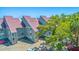 View of the condo building with metal roofs, showing assigned parking, mature trees, and coastal charm at 221 E Mariners Cay # 221, Folly Beach, SC 29439