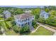 Aerial view of a two-story home surrounded by lush landscaping, showcasing double porches and a driveway at 2269 Hartfords Bluff Cir, Mount Pleasant, SC 29466