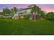 Expansive backyard with lush green lawn, mature trees, and beautiful home exterior with a screened porch at 2269 Hartfords Bluff Cir, Mount Pleasant, SC 29466