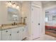 Bright bathroom features a vanity with marble countertops and a door to another room at 2269 Hartfords Bluff Cir, Mount Pleasant, SC 29466