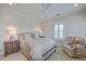 Serene bedroom features neutral tones, bright windows, a ceiling fan, and an accent chair at 2269 Hartfords Bluff Cir, Mount Pleasant, SC 29466