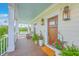Inviting front porch with a swing, chairs, potted flowers, and a wooden front door at 2269 Hartfords Bluff Cir, Mount Pleasant, SC 29466