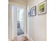 Hallway featuring stylish art, warm wood floors, and an inviting doorway leading to another room at 2269 Hartfords Bluff Cir, Mount Pleasant, SC 29466