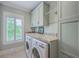 Well-organized laundry room featuring built-in cabinets, granite countertops, and modern washer and dryer at 2269 Hartfords Bluff Cir, Mount Pleasant, SC 29466