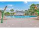 Community pool area featuring chairs, tables, umbrellas, and a clubhouse in the background at 2269 Hartfords Bluff Cir, Mount Pleasant, SC 29466