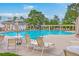 Community pool area featuring chairs, tables, umbrellas, and beautiful tropical landscaping at 2269 Hartfords Bluff Cir, Mount Pleasant, SC 29466