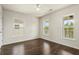 Bright, empty bedroom with hardwood floors and three large windows letting in natural light at 243 Old Savannah Dr, Goose Creek, SC 29445