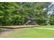 Community playground with swings and climbing structures, set in a lush green space with mature trees at 243 Old Savannah Dr, Goose Creek, SC 29445