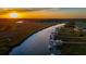 Aerial view showcasing waterfront properties with private docks, river and vibrant sunset sky at 27 Rebellion Rd, Charleston, SC 29407