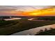 Panoramic aerial view of a riverfront with expansive marshland and a vibrant sunset backdrop at 27 Rebellion Rd, Charleston, SC 29407