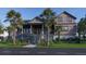 Charming home exterior with mature palm trees, lush landscaping, and a welcoming front porch at 27 Rebellion Rd, Charleston, SC 29407