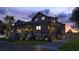 Charming home exterior at dusk with inviting lighting, mature trees, and a golf cart at 27 Rebellion Rd, Charleston, SC 29407