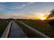 Picturesque view along a wooden walkway to a waterfront gazebo at sunset at 27 Rebellion Rd, Charleston, SC 29407