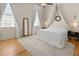 Bright bedroom featuring a canopy bed, hardwood floors, ample natural light from large windows, and a cozy rug at 286 Meeting St # C, Charleston, SC 29407