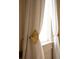 Elegant window detail with decorative curtain tie-backs, adding a touch of sophistication to the room's decor at 286 Meeting St # C, Charleston, SC 29407