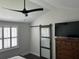 Bedroom featuring a ceiling fan, a window with white shutters, and a sliding barn door at 31 Wedgepark Rd, Charleston, SC 29407